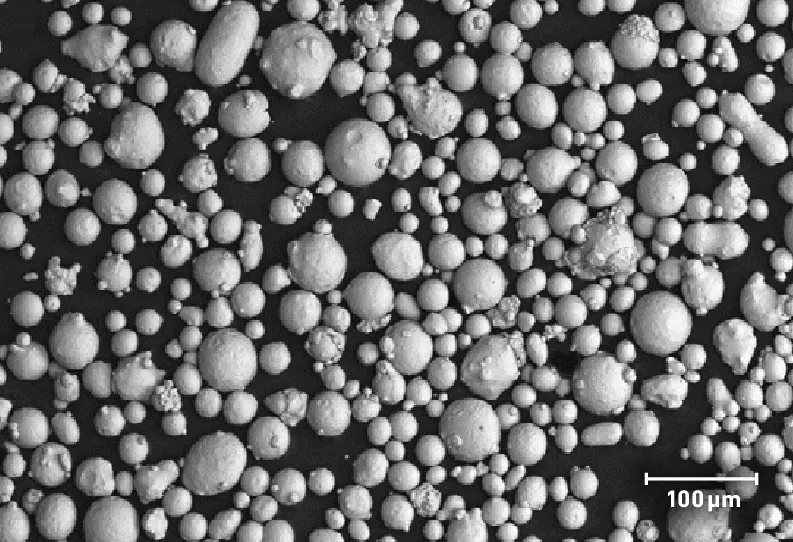SEM image of typical PowderRange 316L powder, from the Carpenter Additive datasheet. Spherical, nitrogen gas-atomized particles; scale bar 100 µm.