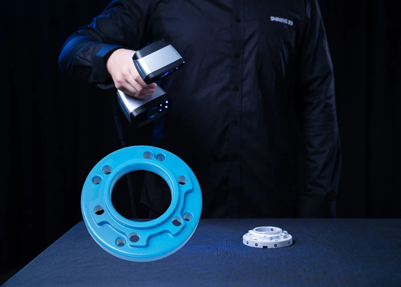 EinScan HX2 scanning a cast-metal flange next to its blue 3D scan-result model