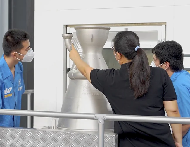 Engineers with a 780 mm IN718 combustion chamber printed on the Farsoon FS621M metal LPBF system