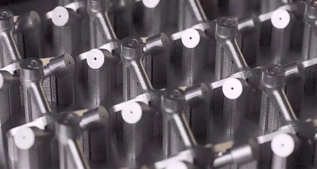 Close-up of complex metal parts on the build plate after LPBF printing on the Farsoon FS422M