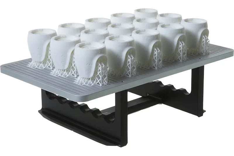 Batch of white LSPc printed parts on a Nexa3D build plate